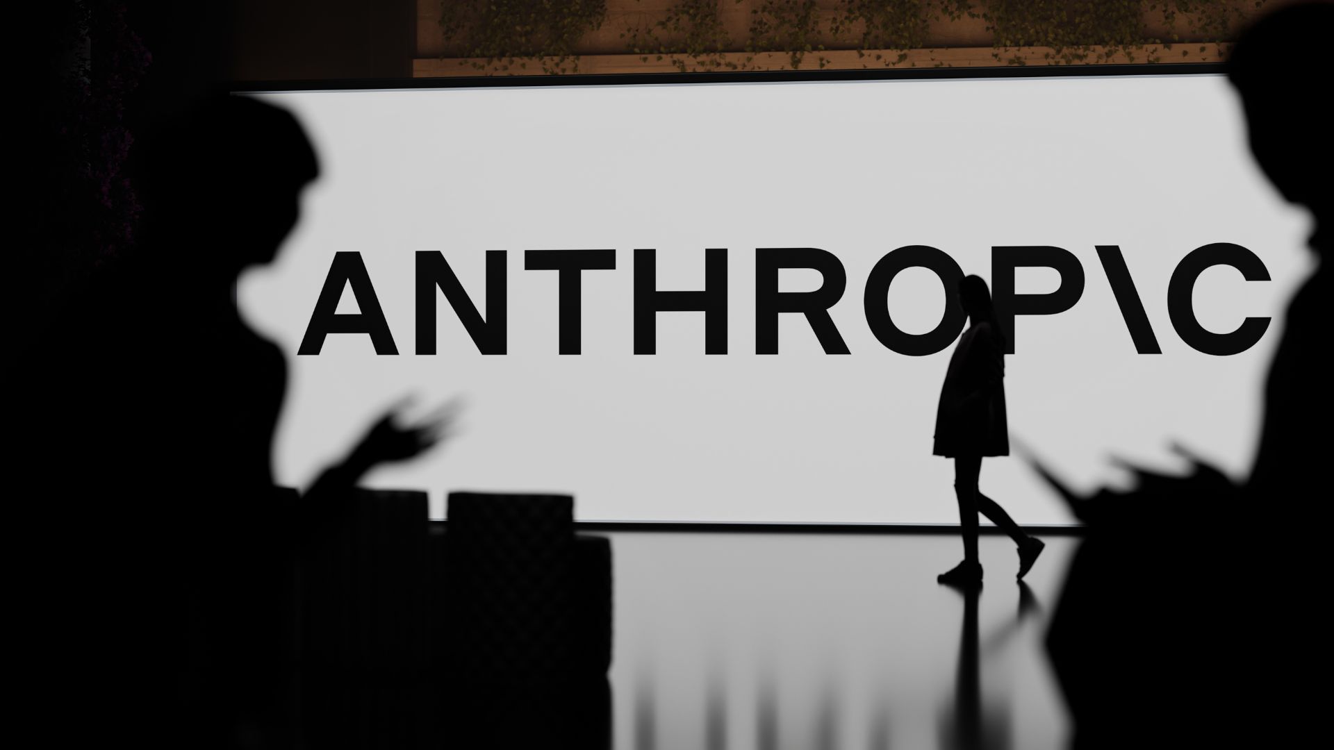 Attendees at an Anthropic event stand before a large screen displaying the ANTHROPIC logo