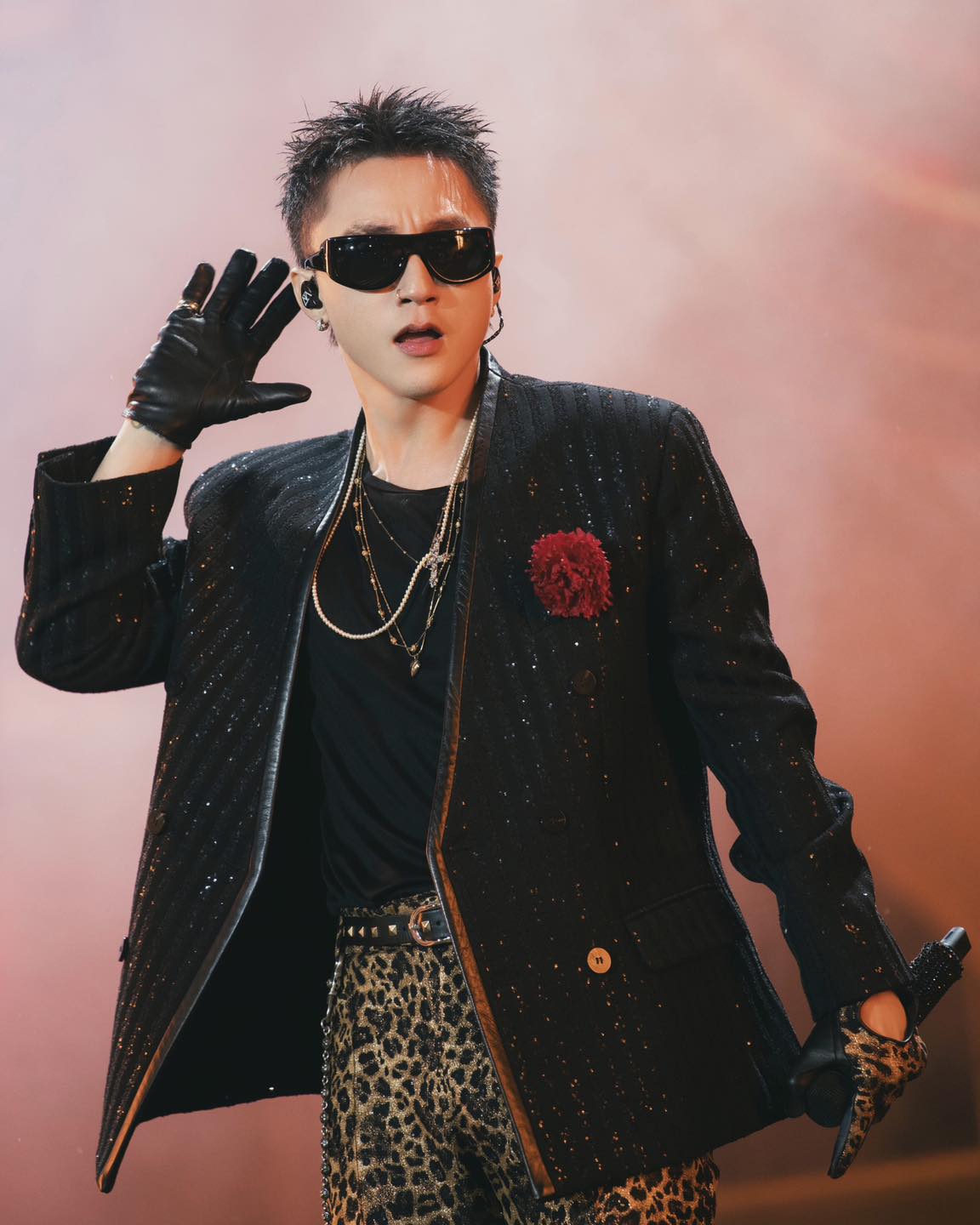 Sơn Tùng M-TP performing on stage in a sequined jacket during a 2024 fan meeting